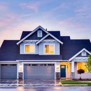 Beautiful two-story house with illuminated windows and garage at dusk.